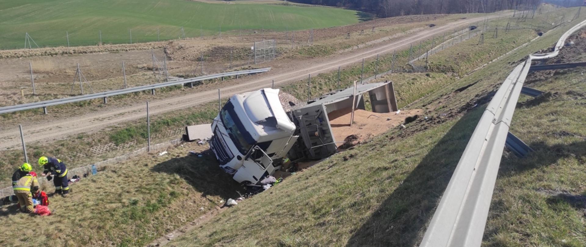 Samochód ciężarowy po wypadku leży w rowie.