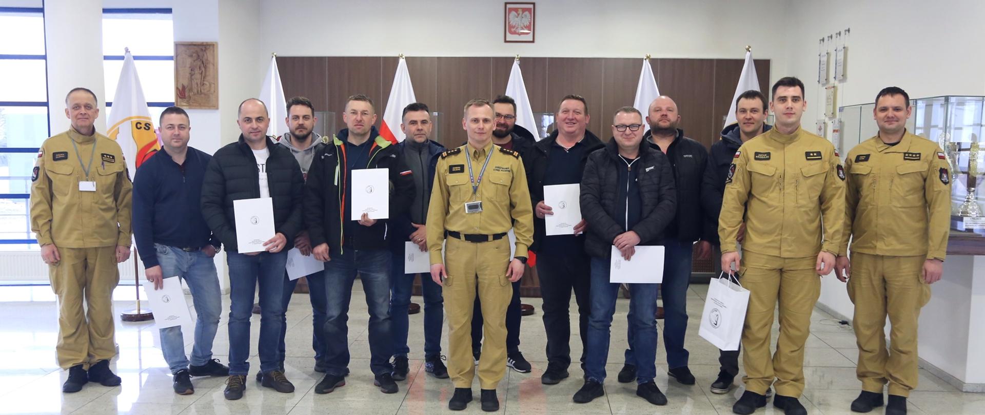 Grupowe zdjęcie uczestników szkolenia (10 osób) w towarzystwie Zastępcy Komendanta Centralnej Szkoły PSP oraz trzech oficerów CS PSP