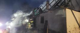 Zdjęcie przedstawia pracujących strażaków podczas pożaru w Bystrej Podhalańskiej. Palił się budynek mieszkalny. 