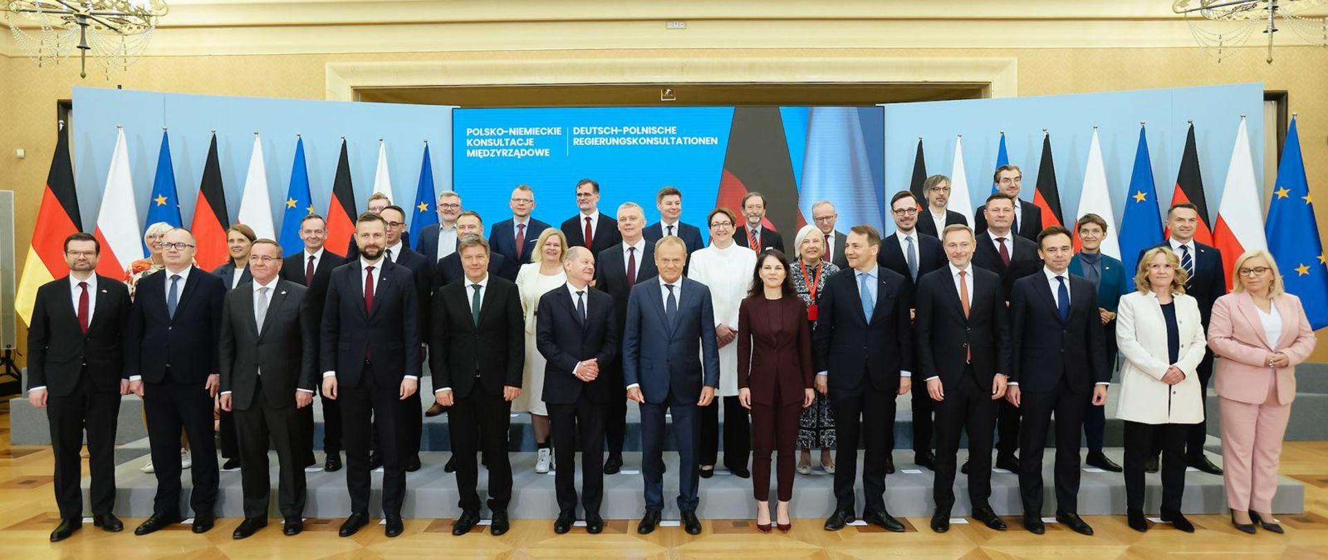 Grupa osób stoi ustawiona w trzech rzędach na scenie.