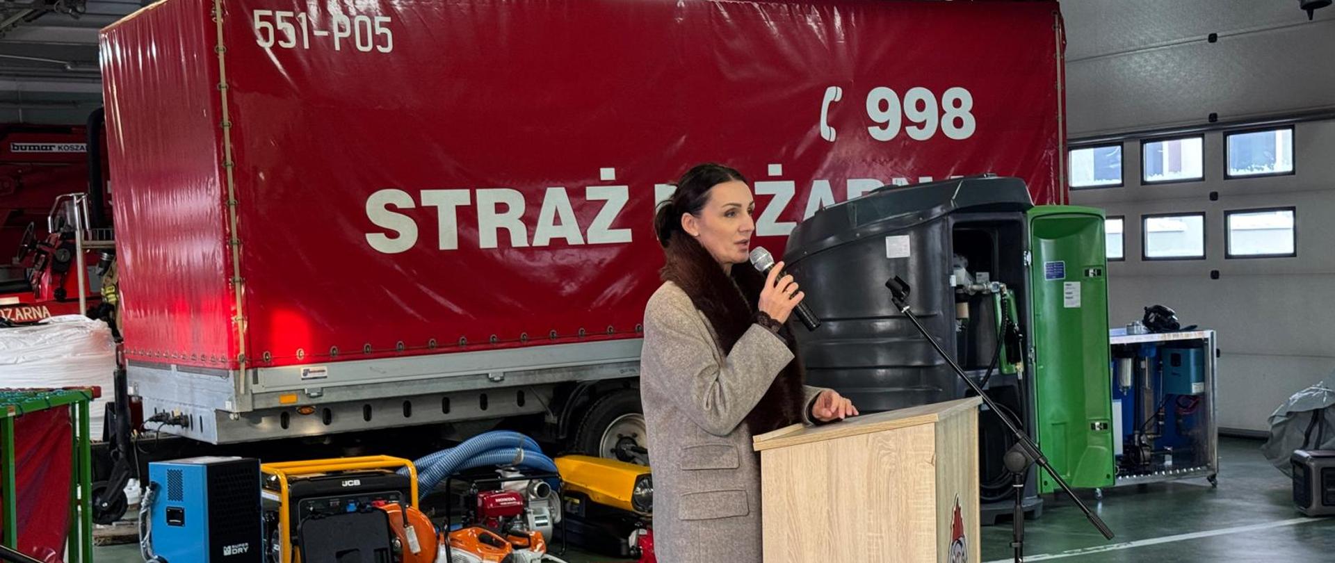 wojewoda przemawia, w tle wóz strażacki