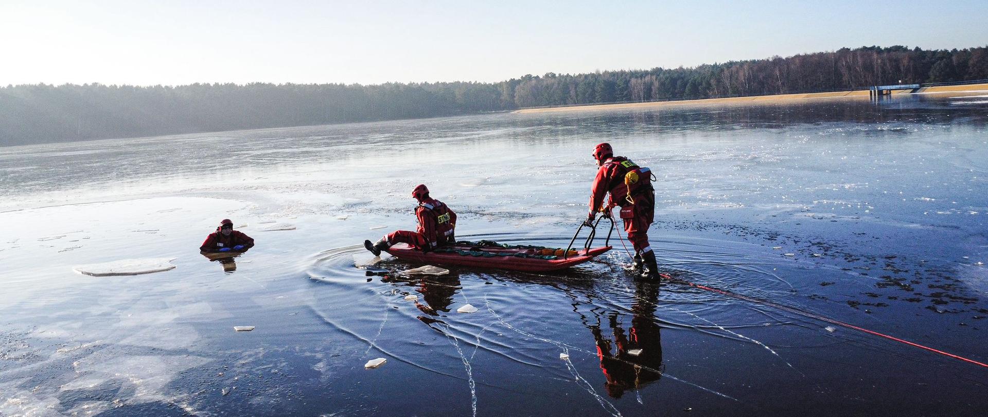 Ratownicy ćwiczą podejmowanie osoby pod którą załamał się lód z wykorzystaniem sań wodno-lodowych