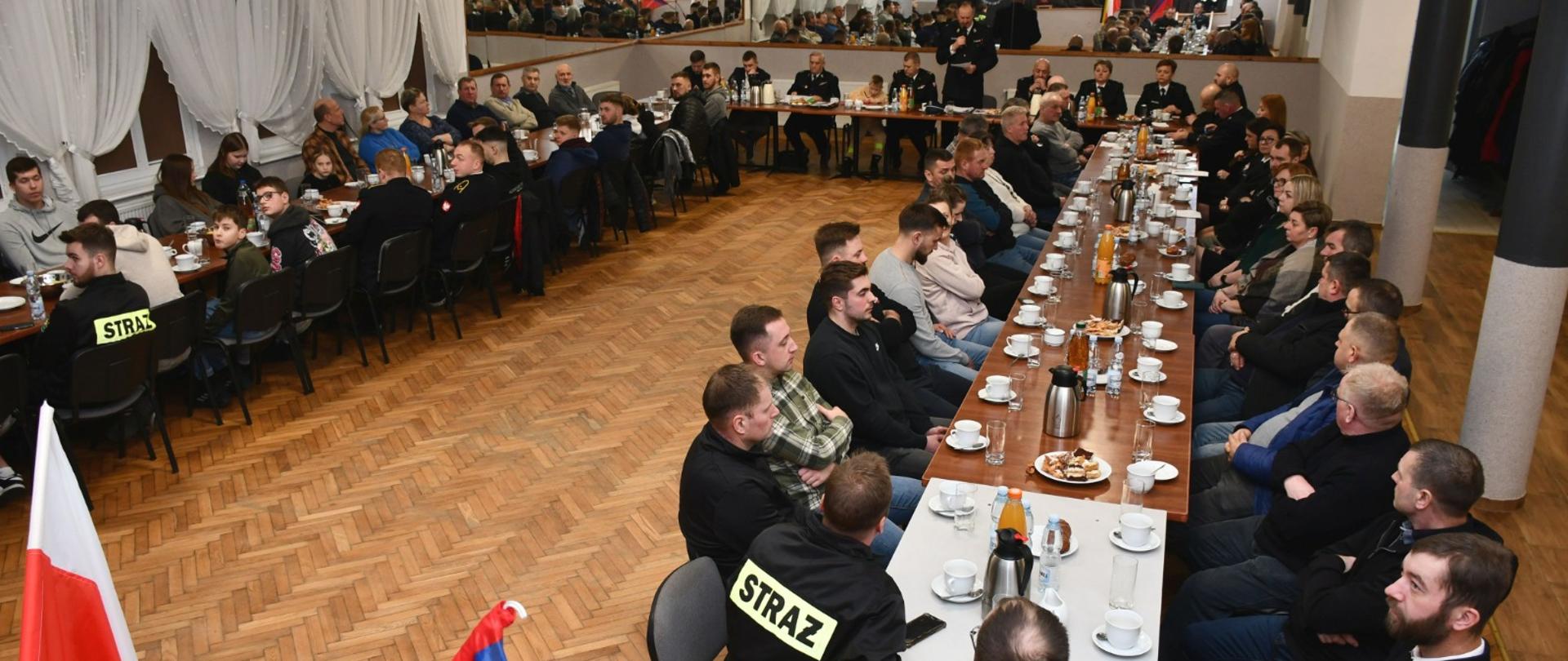 Uczestnicy spotkania siedzą przy stole. 