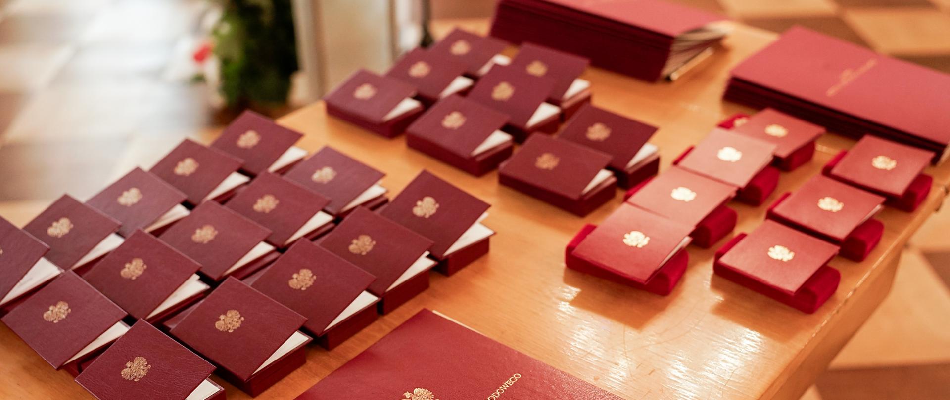 Na zdjęciu na brązowym stolik odznaczenia i medale dla nauczycieli szkół artystycznych z okazji Dnia Edukacji Narodowej