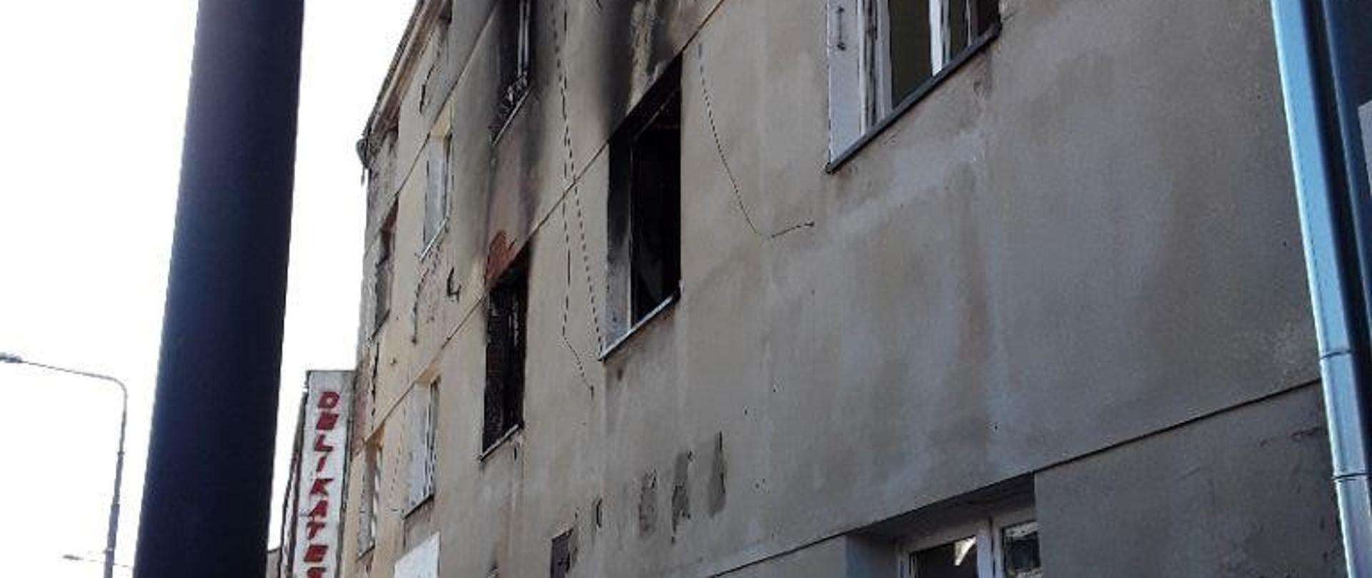 Budynek kamienicy w którym doszło do pożaru. Okopcone okna mieszkania na pierwszym piętrze.