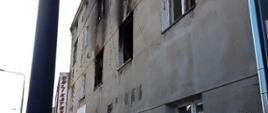 Budynek kamienicy w którym doszło do pożaru. Okopcone okna mieszkania na pierwszym piętrze.