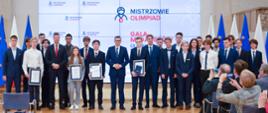 Wiceminister Dariusz Piontkowski i premier Mateusz Morawiecki pozuje do zdjęcia z olimpijczykami