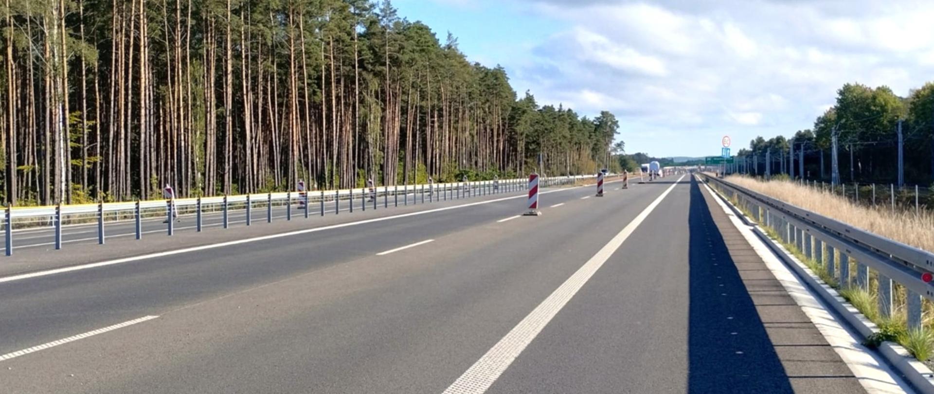 Odcinek drogi ekspresowej S3 Świnoujście–Dargobądz w trakcie końcowych prac przed dopuszczeniem do użytkowania, widoczna jezdnia z barierami ochronnymi oraz oznakowaniem drogowym, w tle las.