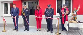 Zastępca komendanta głównego PSP wraz z druhem OSP oraz kobietą i mężczyzną przecinają wstęgę na otwarcie Centrum