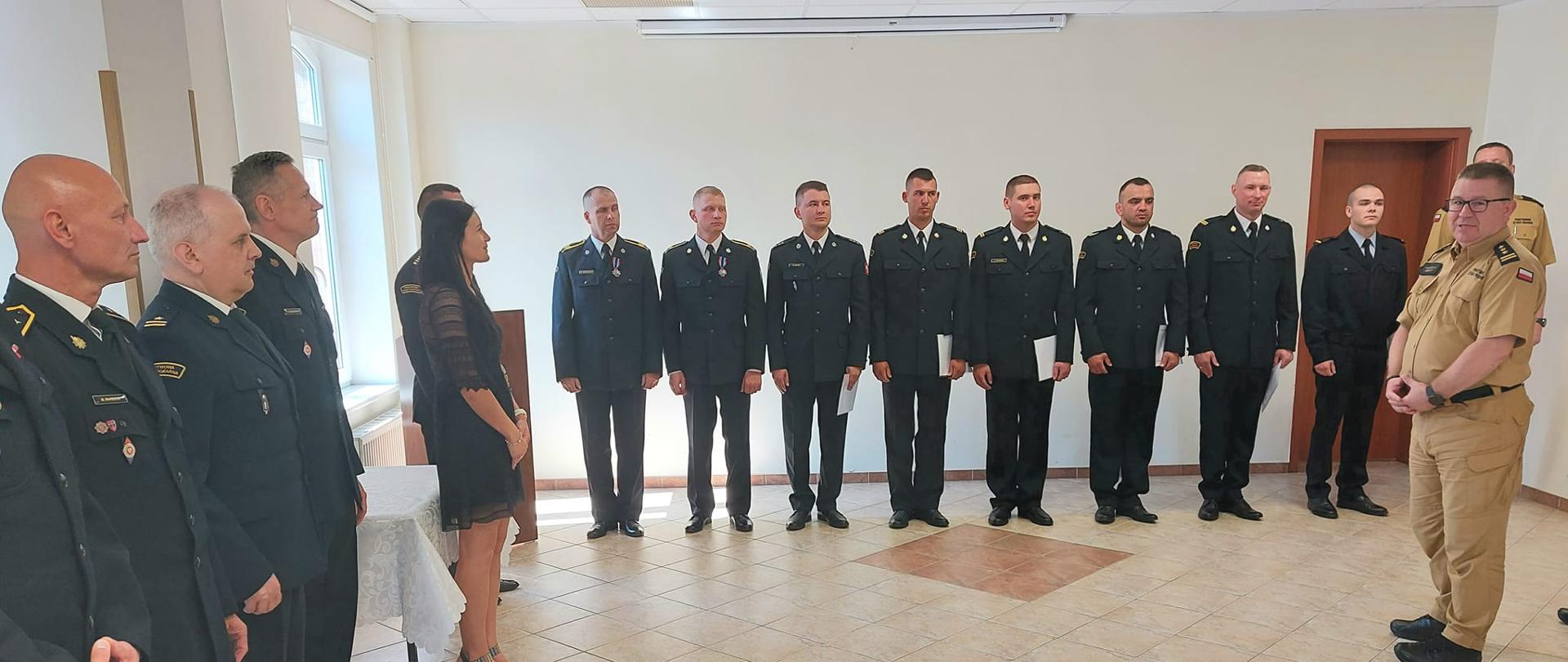 Zdjęcie przedstawia uroczystość w Komendzie Miejskiej PSP w Słupsku, podczas której wręczone zostały wyróżnienia i nagrody funkcjonariuszom PSP.