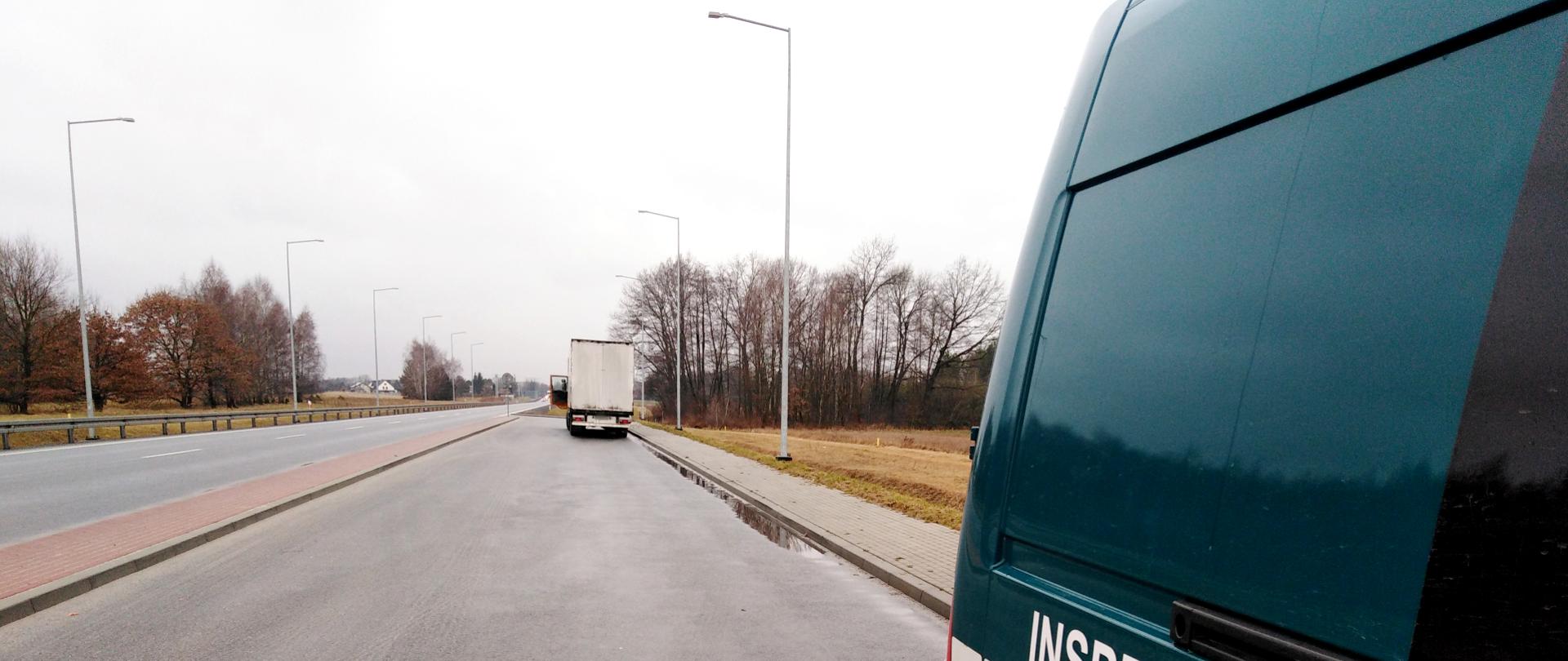 Zatrzymana ciężarówka, w której inspektorzy z WITD w Krakowie udaremnili manipulowanie czasem pracy kierowcy. Na pierwszym planie furgon ITD, w tle skontrolowany pojazd stojący na przydrożnym parkingu.
