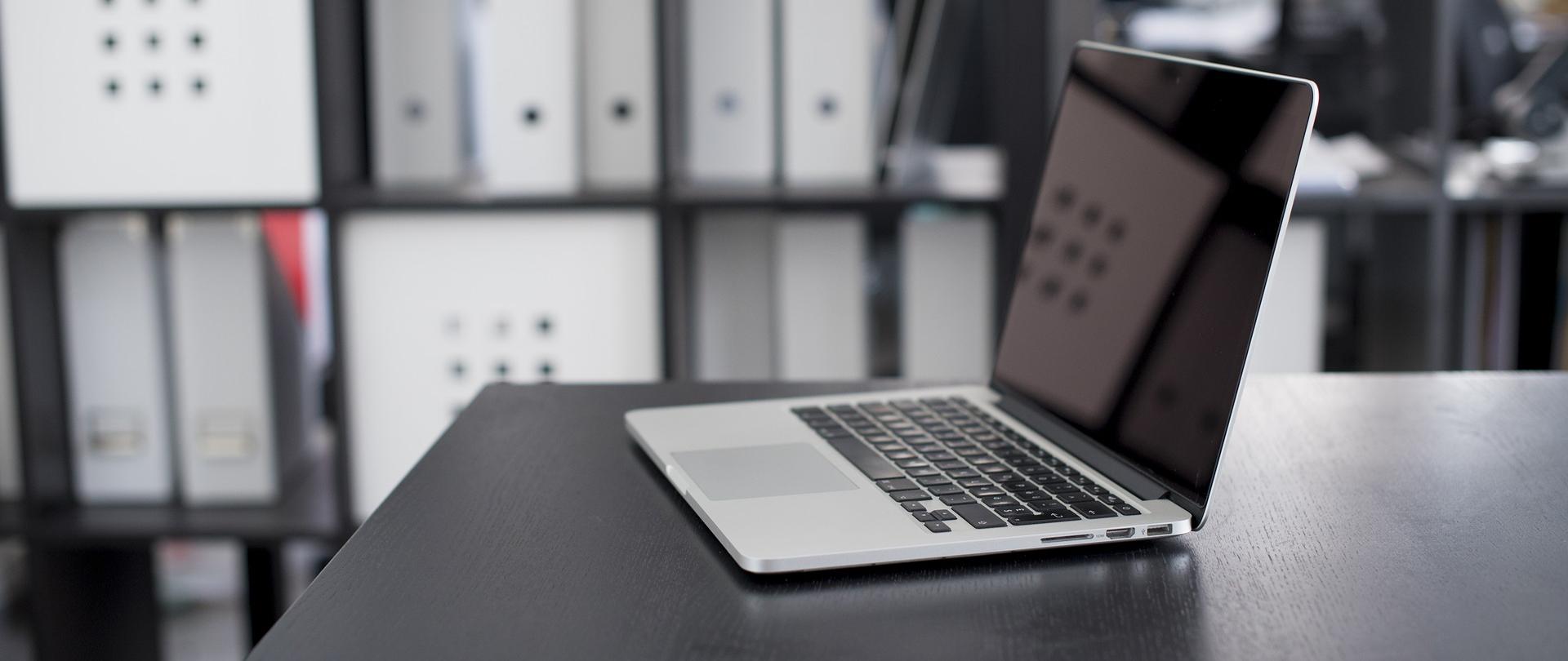 laptop na brązowym blacie.