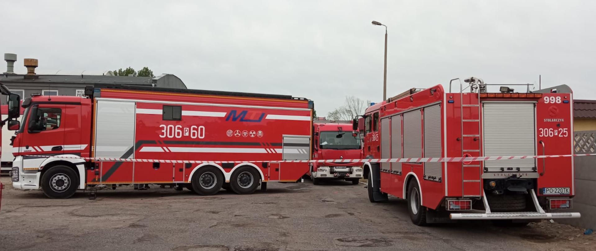 Na zdjęciu widać trzy samochody strażackie odgrodzone taśmą ostrzegawczą