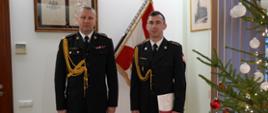 Komendant Wojewódzki PSP w Poznaniu nadbrygadier Dariusz Matczak wraz z nowym Komendantem PSP w Gostyniu. W tle sztandar Komendy Wojewódzkiej PSP w Poznaniu obok choinka