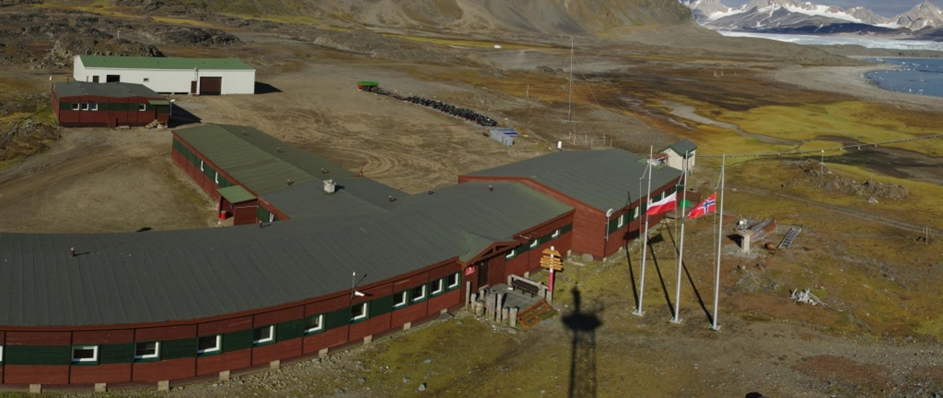 Polska stacja polarna - parterowe pawilony na tle gór, z prawej zatoka