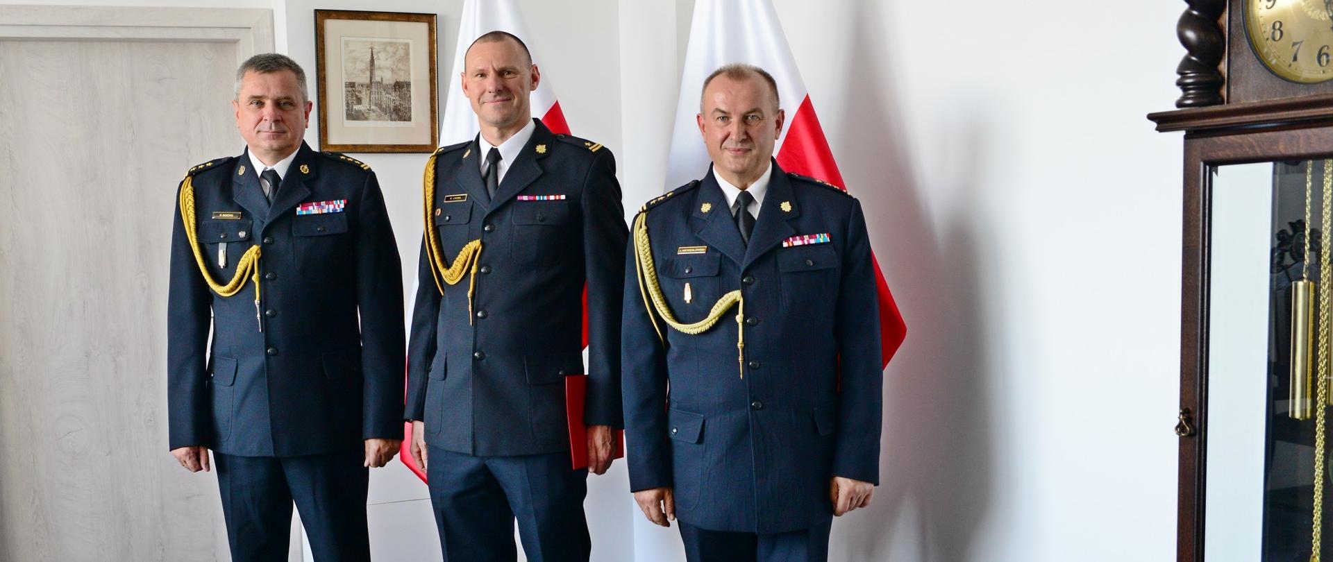 Pomorski komendant wojewódzki PSP, komendant powiatowy PSP w Wejherowie oraz powołany funkcjonariusz PSP stoją wspólnie po wręczeniu aktu powołania.
