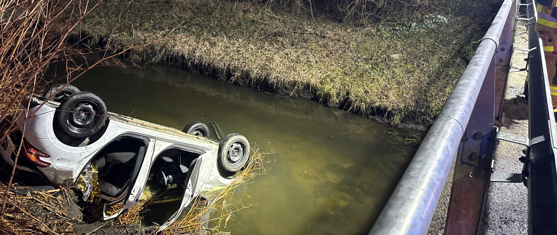 Samochód po wypadku w rzece leżąc na dachu
