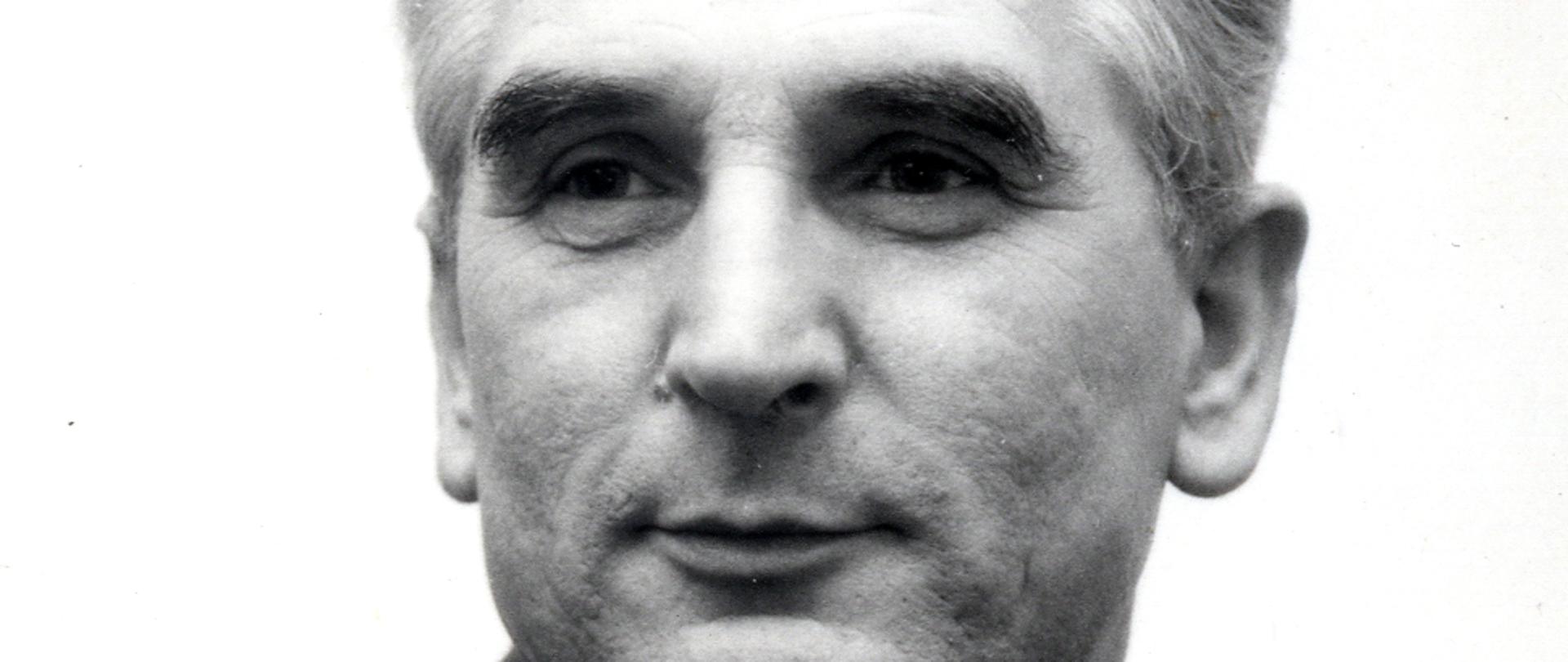 Józef Czyrek czarno - biały portret mężczyzny. siwe włosy, szara marynarka w paski, wzorzysty krawat, biała koszula.