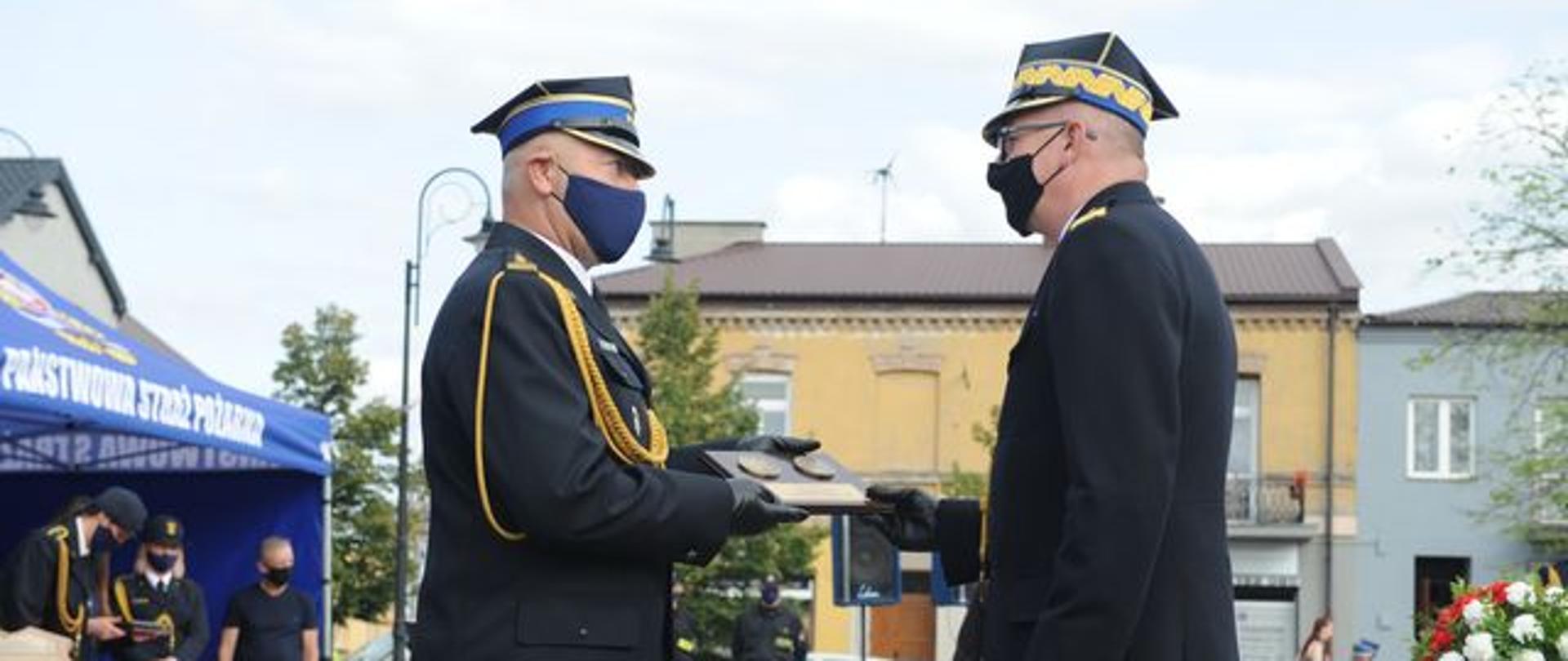 zdjęcie przedstawia komendanta powiatowego wręczającego podziękowania zastepcy komendanta głównego