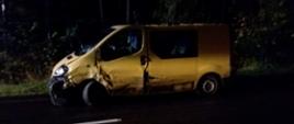 Samochód dostawczy w kolorze żółtym stoi na jezdni, na prawym pasie ruchu. Zdjęcie wykonane z boku przedstawia uszkodzenia pojazdu po wypadku. Kadr doświetlony światłem sztucznym z uwagi na porę nocną zdarzenia. 