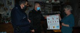 Na zdjęciu policjant oraz strażak podczas prowadzenia akcji informacyjno-edukacyjnej o zagrożeniach pożarowych