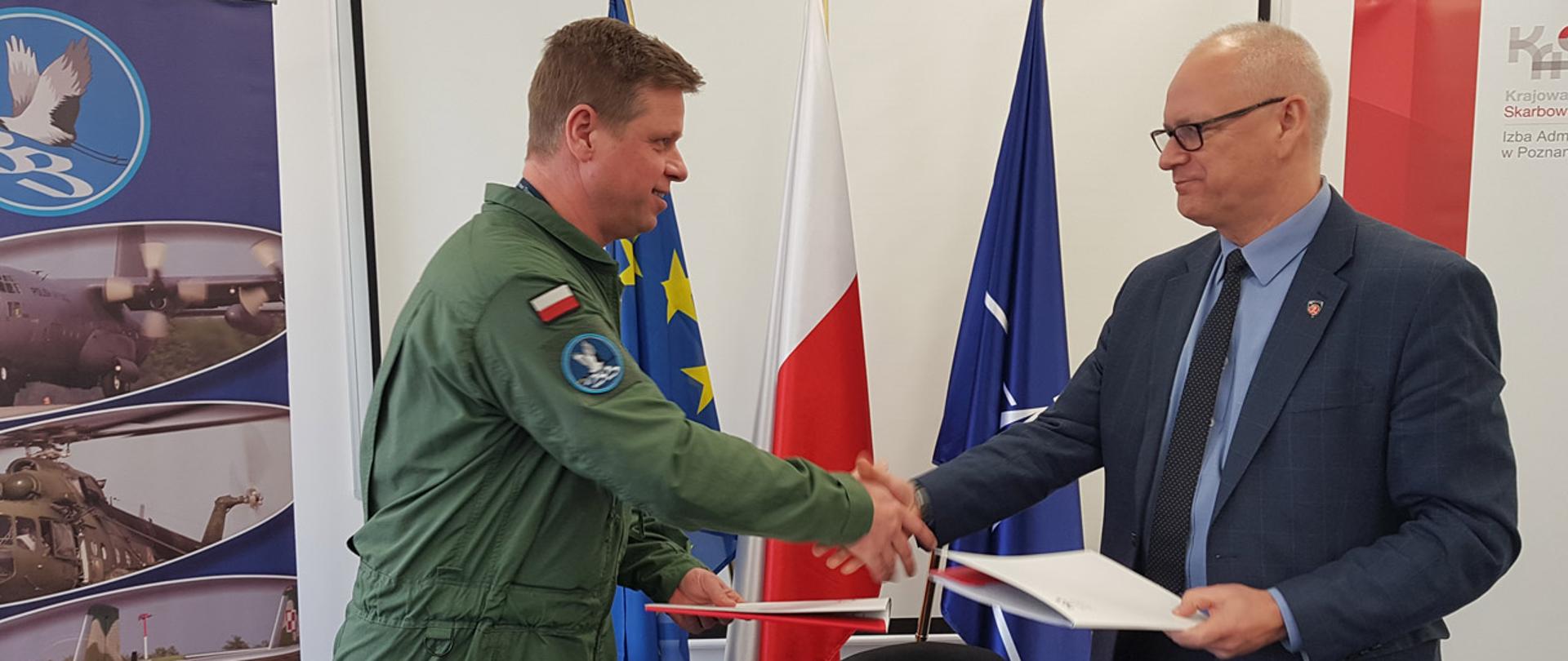 Dyrektor Izby Administracji Skarbowej w Poznaniu z dowódcą bazy, przekazują sobie podpisane dokumenty.
