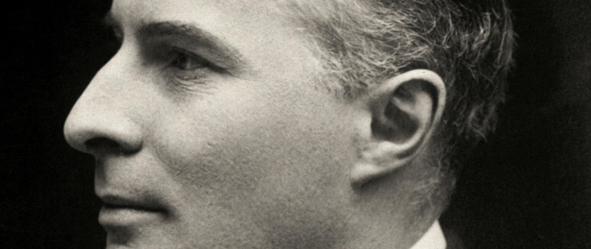 Eustachy Sapieha - czarno-białe portretowe, profilowe zdjęcie mężczyzny. Ciemne włosy, ciemna marynarka, ciemny krawat, biała koszula.