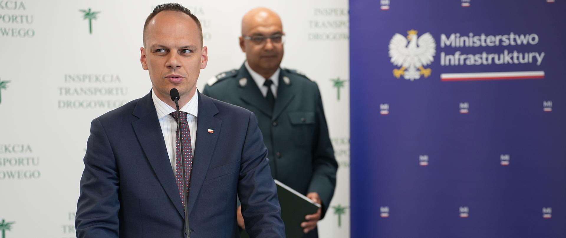 Wiceminister infrastruktury Rafał Weber w trakcie briefingu w siedzibie Głównego Inspektoratu Transportu Drogowego. Z tyłu Główny Inspektor Transportu Drogowego Alvin Gajadhur