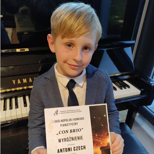 Zdjęcie Antosia Czech trzymający dyplom z konkursu Con Brio