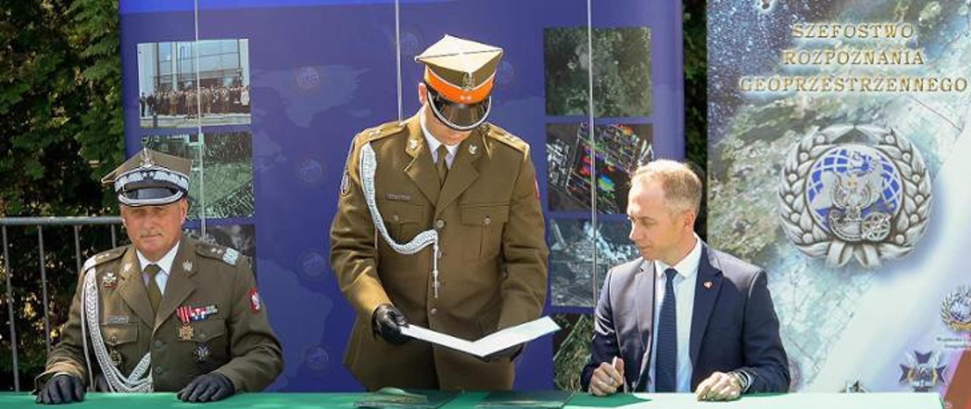Zdjęcie przedstawia w uroczystość przekazania Szefostwa Rozpoznania Geoprzestrzennego w Warszawie wraz z jednostkami bezpośrednio podległymi do Agencji Rozpoznania Geoprzestrzennego i Usług Satelitarnych (ARGUS) oraz podporządkowania jej sekretarzowi stanu w Ministerstwie Obrony Narodowej.