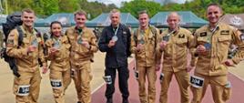 7 zawodników PSP reprezentacji województwa mazowieckiego po ukończonym biegu prezentuje pamiątkowe medale. 