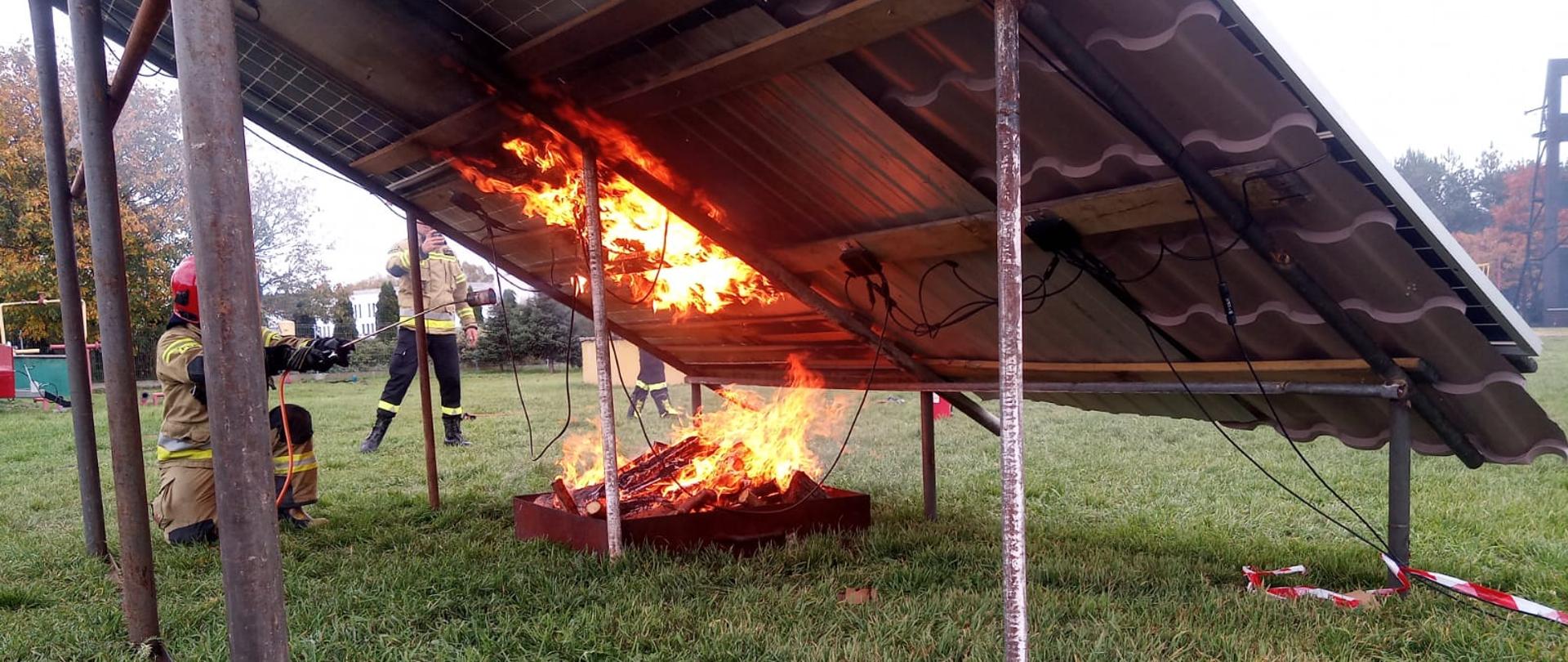 Strażacy podpalają panel fotowoltaiczny.