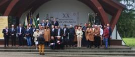Grupa osób pozuje do zdjęcia stojąc na scenie amfiteatru
