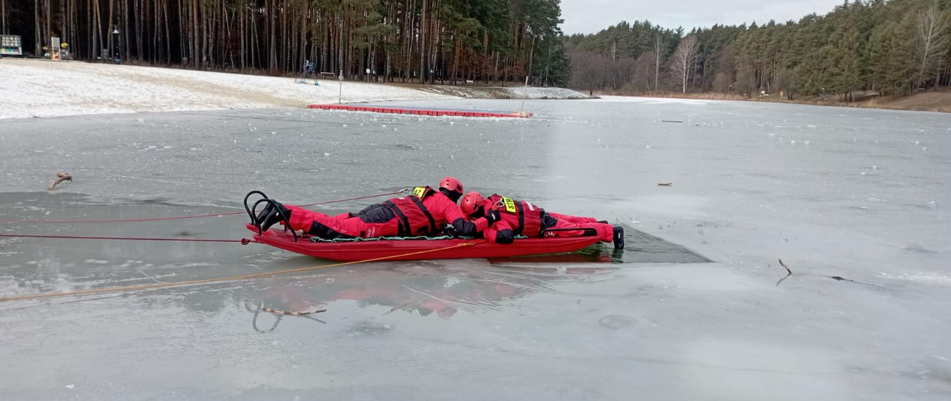 Zdjęcie przedstawia zalew Andrzejówka i technikę ratownictwa lodowego z wykorzystaniem sań lodowych. 