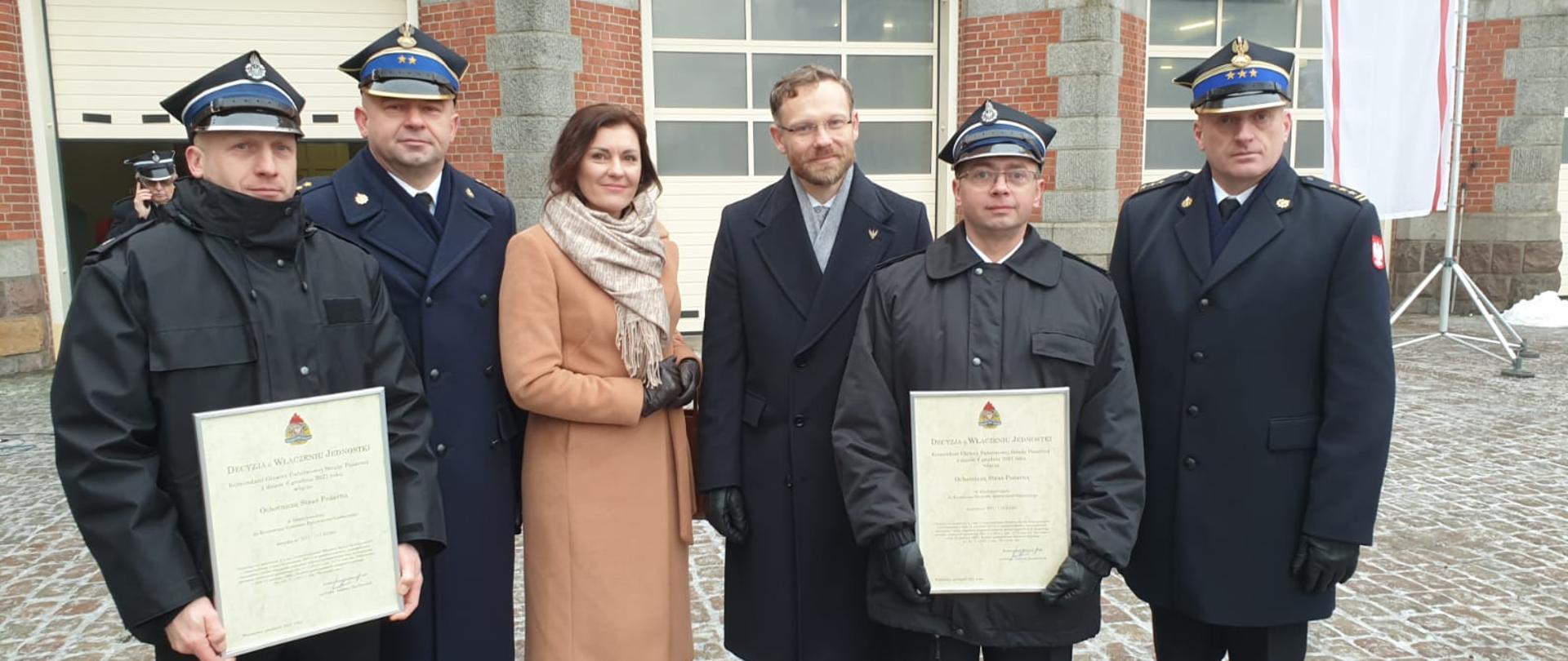 Zdjęcie przedstawia przedstawicieli straży pożarnej oraz urzędu na tle jednostki PSP