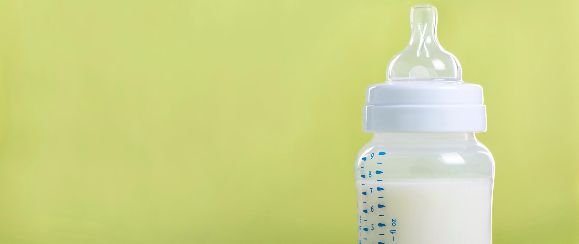 Baby milk bottle on a green sheet