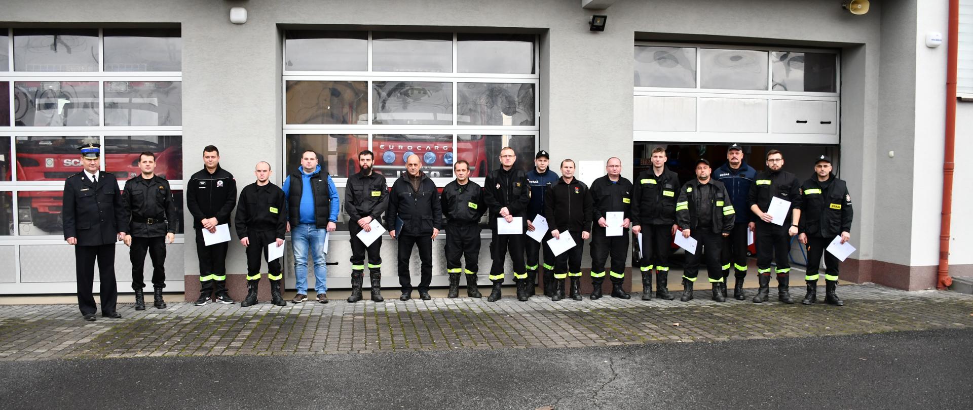 Na zdjęciu widzimy funkcjonariuszy Państwowej Straży Pożarnej oraz strażaków Ochotniczych Straży Pożarnych pozujących do zdjęcia na tle budynku Jednostki Ratowniczo Gaśniczej w Leżajsku.