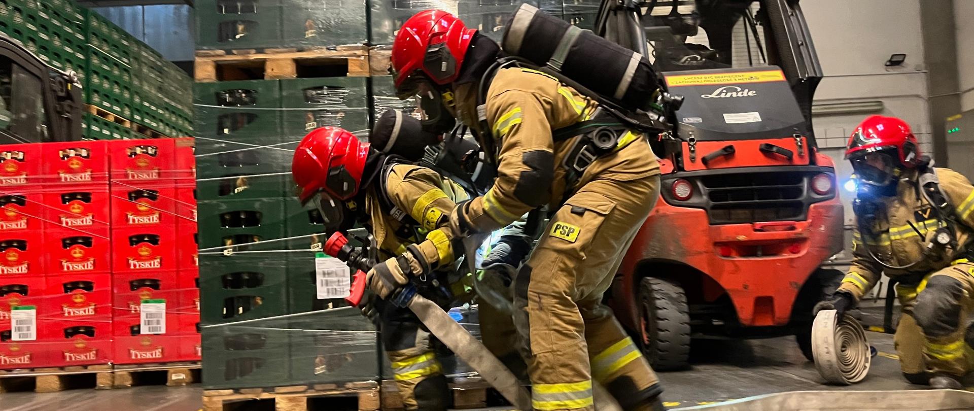 Strażacy wewnątrz hali magazynowej