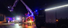Widoczne pojazdy gaśnicze oraz podnośnik hydrauliczny oraz 3 strażaków na bojowo