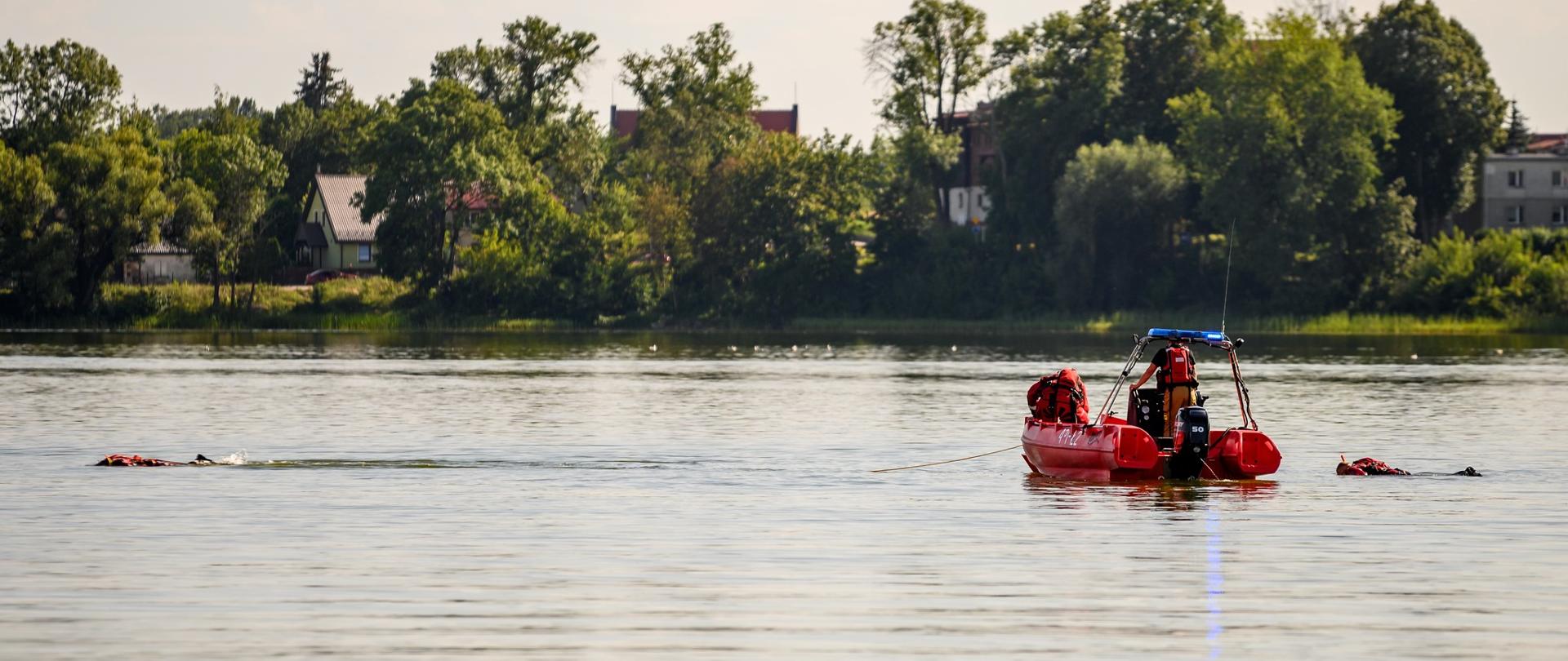 Strażacy na łodzi i powierzchni wody poszukują mężczyzny
