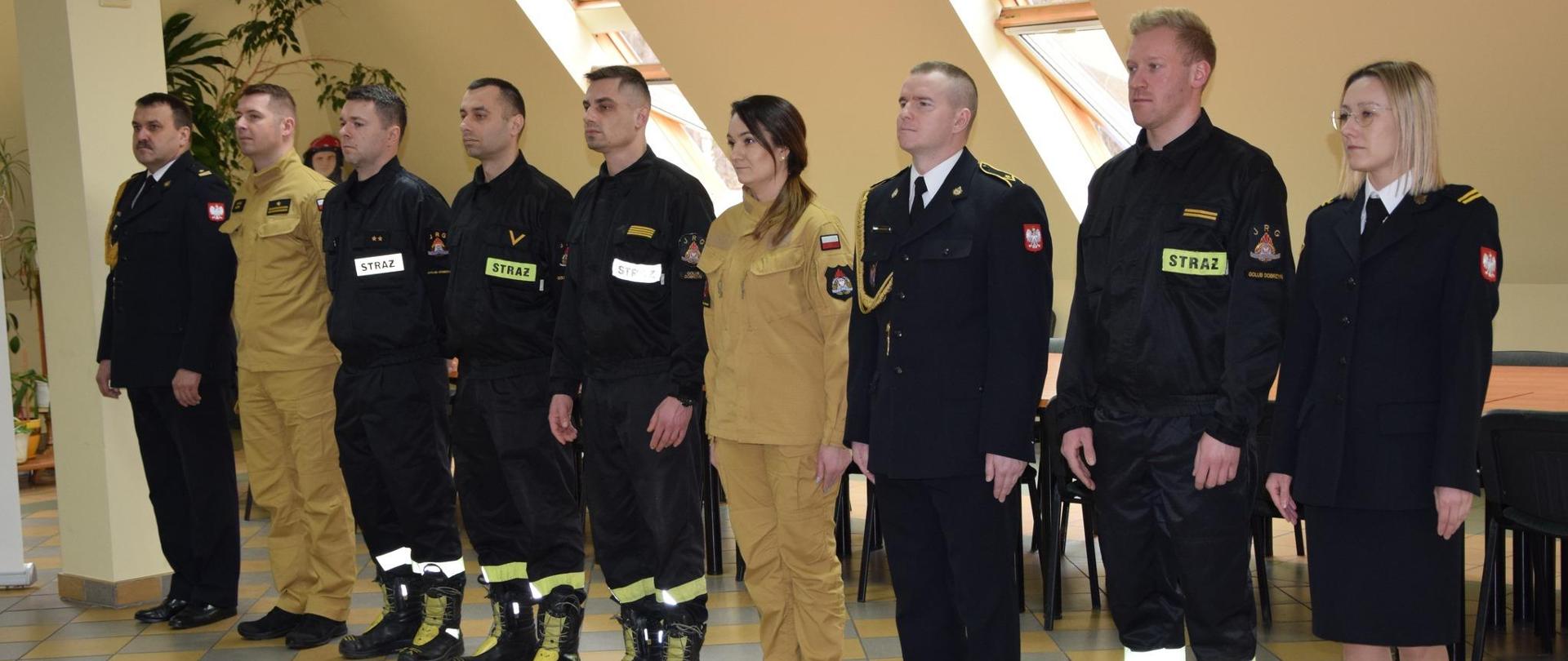 Awansowani funkcjonariusze oraz nowoprzyjęty strażak stoją w szeregu.