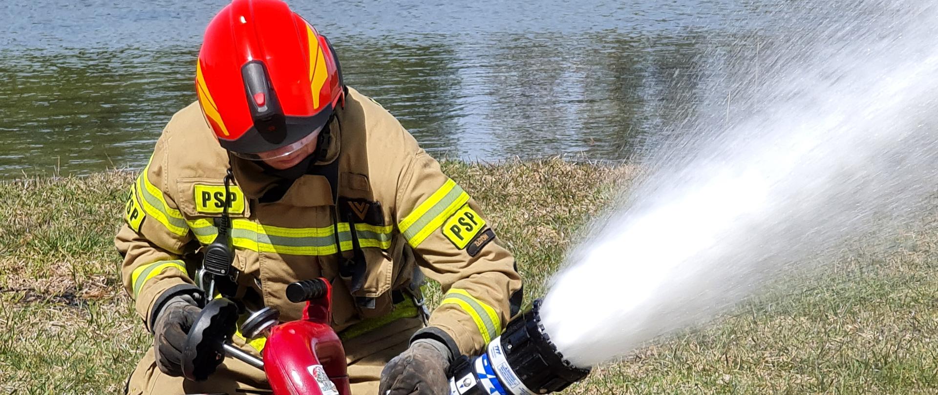 Na zdjęciu strażak , który operuje działko wodne 