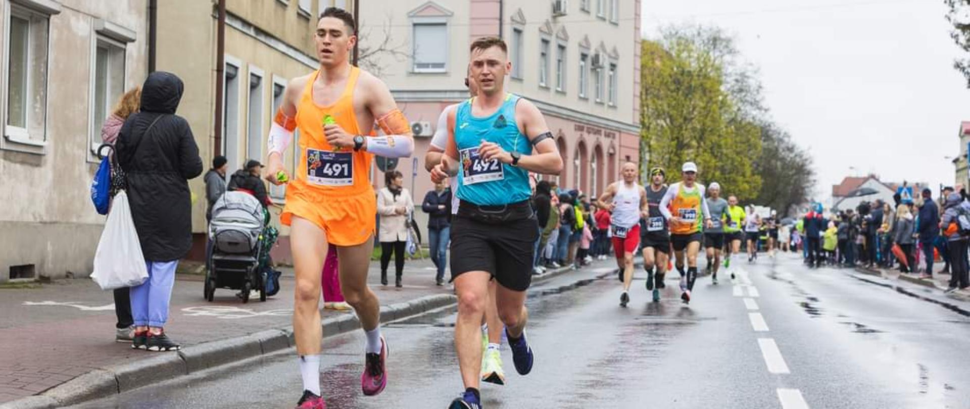 Dwóch mężczyzn biegnących w strojach sportowych