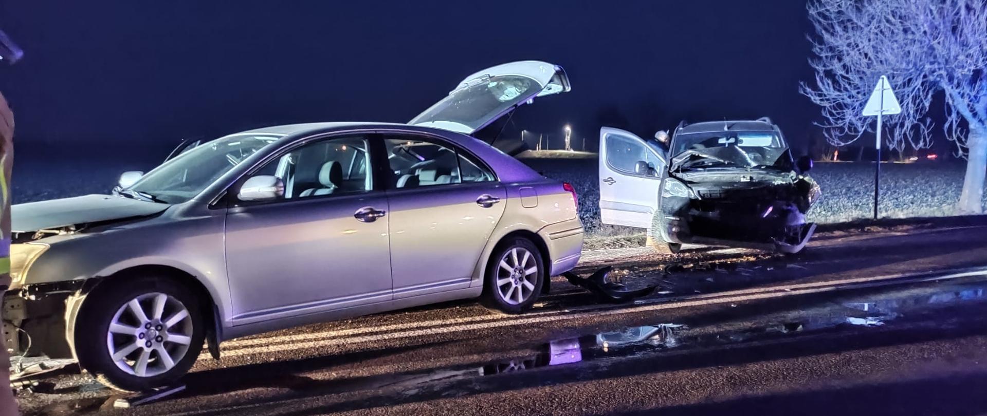 Zdjęcie przedstawia z lewej strony srebrny samochód osobowy z uszkodzonym przodem, po prawej strony drujgi srebrny samochód z uszkodzonym przodem
