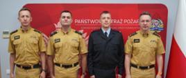 Strażacy mianowani na stanowiska wspólnie z Komendantami. W tle ścianka PSP.