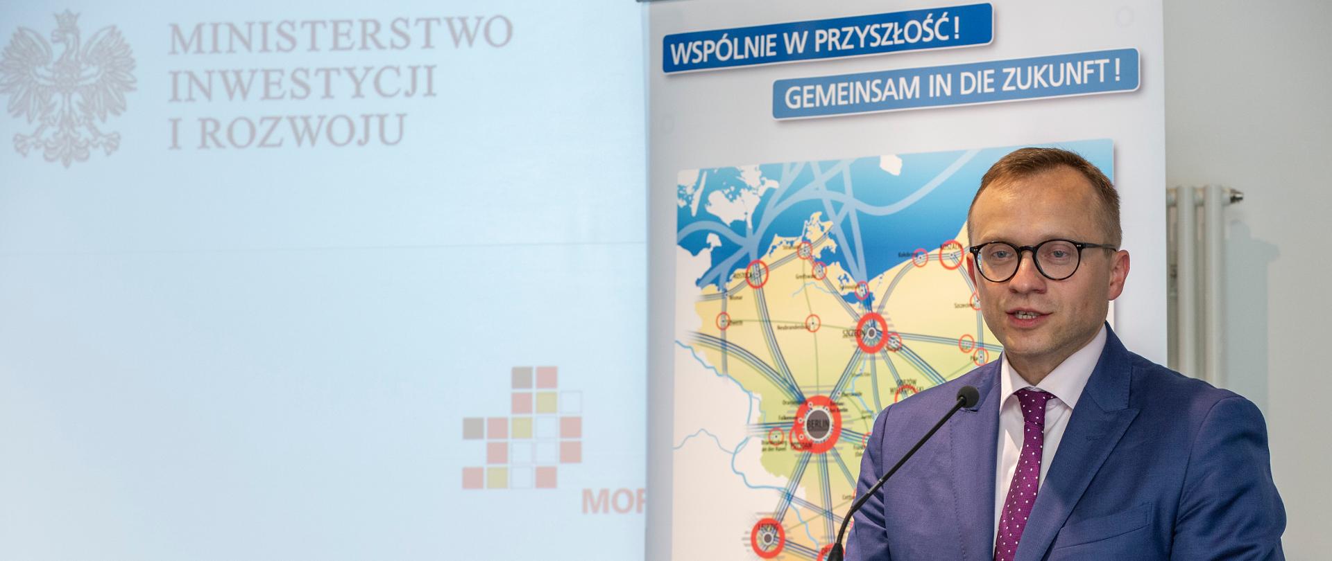 za pulpitem przed mikrofonem stoi wiceminister Artur Soboń