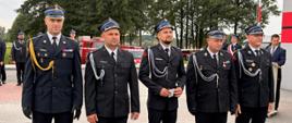 „Wyróżnieni strażacy OSP na czele z Komendantem Powiatowym PSP w Węgrowie bryg. Mateuszem Bieniakiem po zakończonej ceremonii wręczenia odznaczeń i awansów, ustawieni w rzędzie na placu apelowym.”