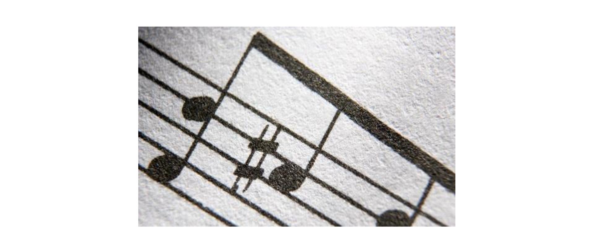 Biało-czarny plakat. W nagłówku informacja o koncercie laureatów konkursów i zespołów PSM I stopnia w Oławie. Na środku strony grafika przedstawiająca pięciolinię i znajdujące się na niej nuty. Na dole strony informacje o dacie i miejscu koncertu.