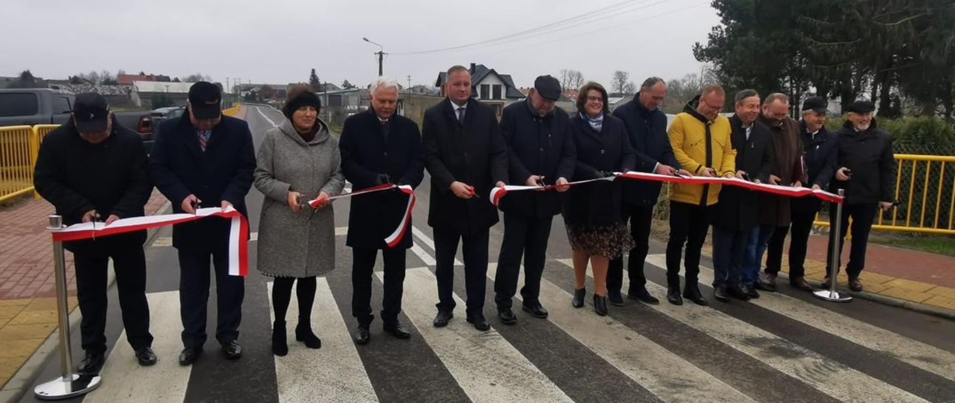 Na zdjęciu widać kobiety i mężczyzn podczas oficjalnego oddania do użytku drogi powiatowej