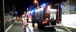 zdjęcie przedstawia samochody ratowniczo gaśnicze straży pożarnej stojance jeden za drugim na ulicy w czasie akcji gaśniczej